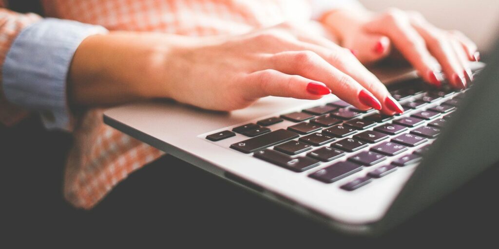 Hands typing on a Mac