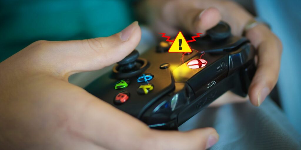 Xbox One controller in hands with warning symbol above