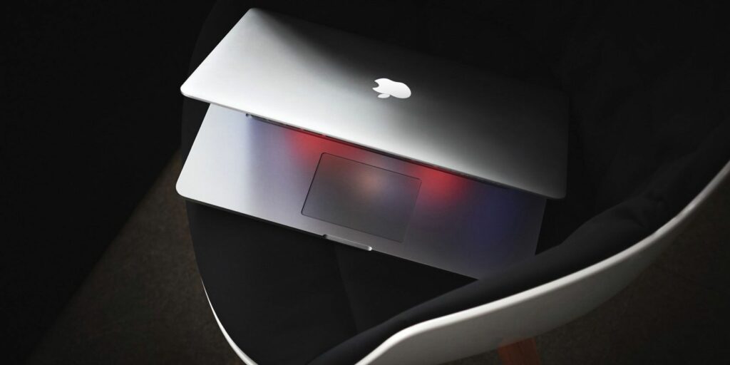 MacBook opening on a dark chair