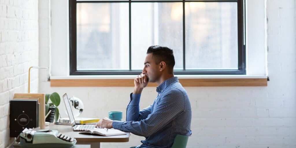 Man working on a computer in front of a window