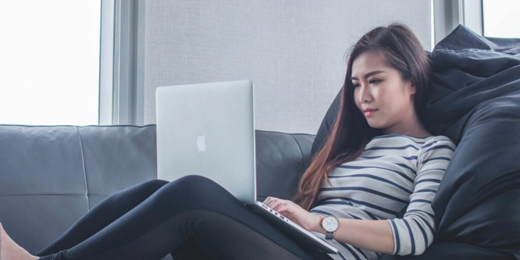 Person sitting on a couch, using a laptop