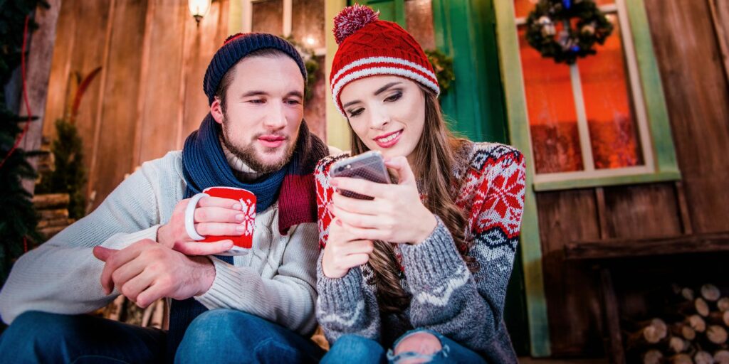 couple in winter clothing on a phone