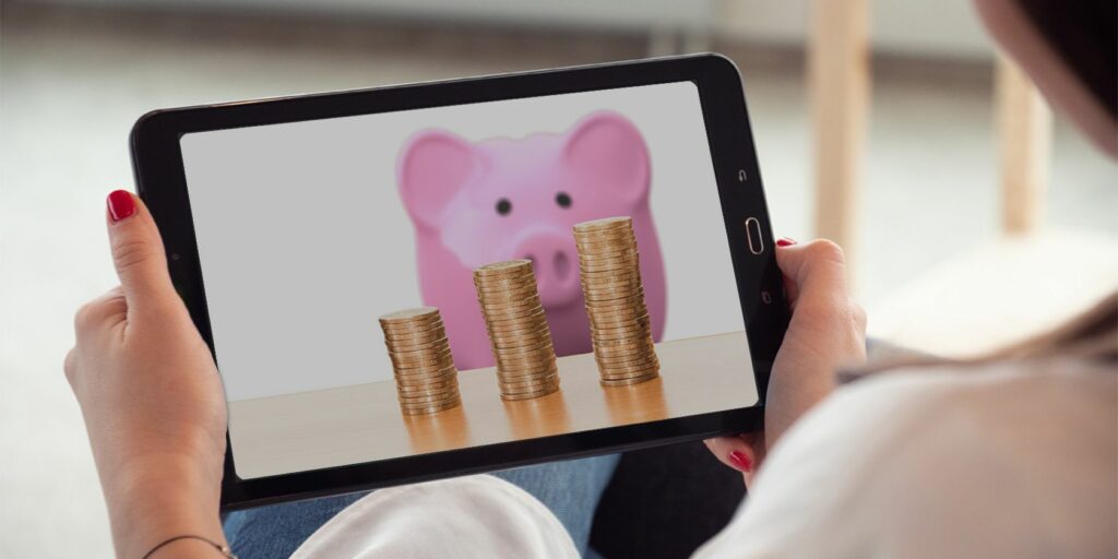 Budget tablet with piggybank and coins on the screen