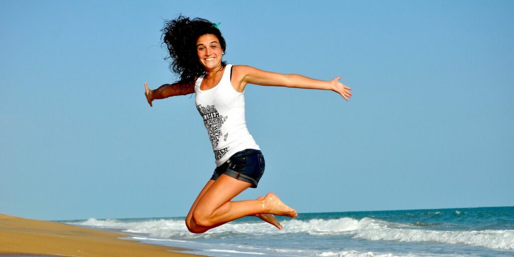 woman-jumping-beach-happy