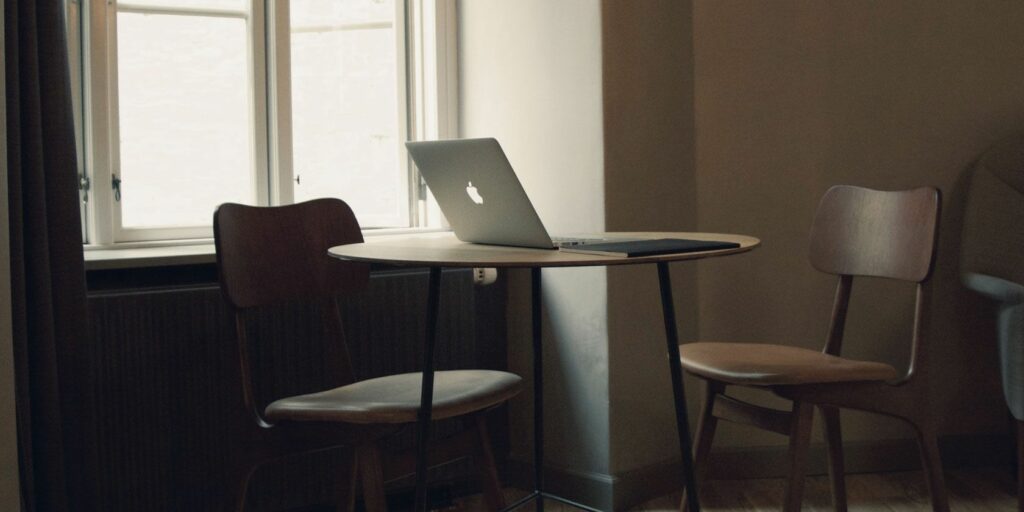 MacBook on a table by a window