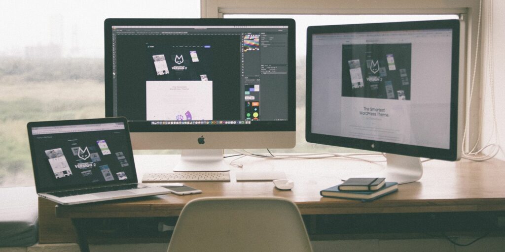 Multiple Mac screens and monitors showing the Dock on one.