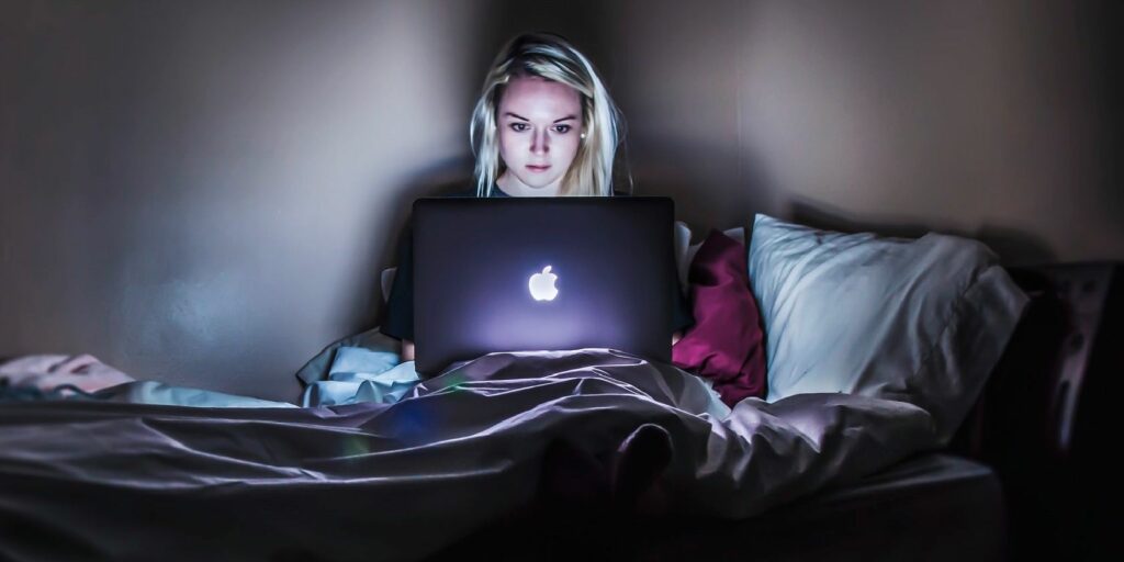 Person Using Laptop on Bed