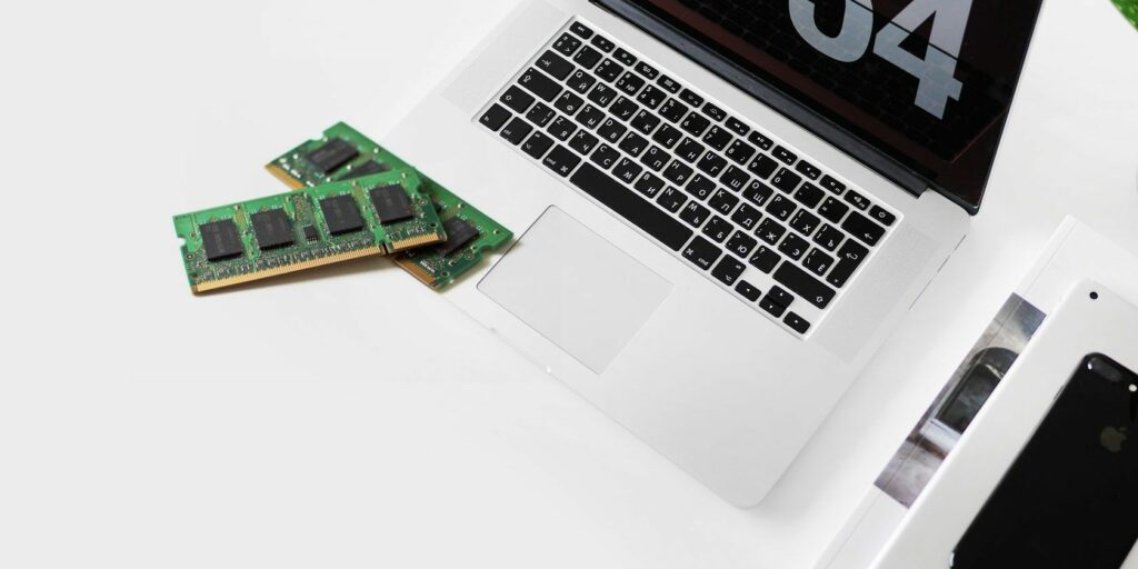 MacBook next to two sticks of RAM